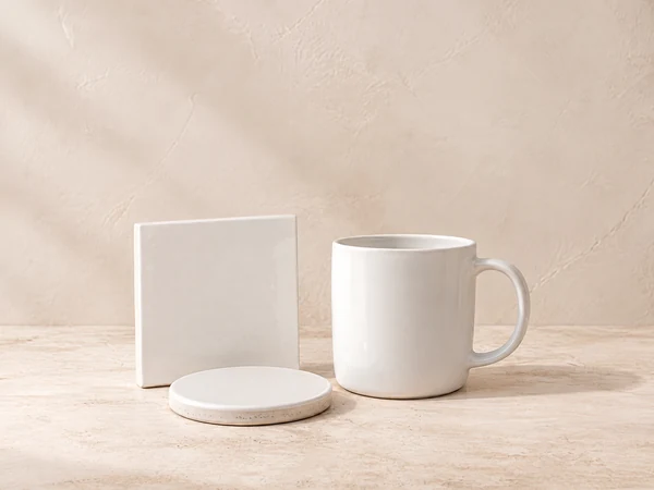 Weiße Keramiktasse, Fliese und Untersetzer