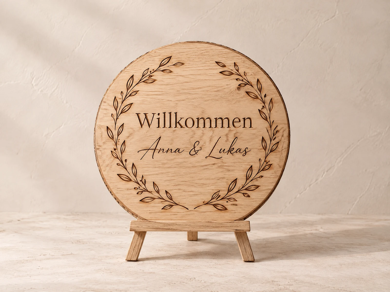 Rundes Eichenschild mit Gravur „Willkommen, Anna & Lukas“ auf einer Staffelei